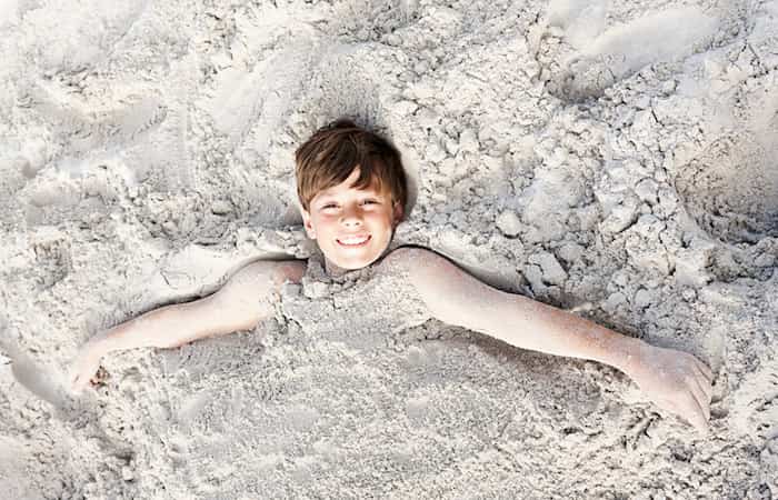 Niño enterrado en la arena
