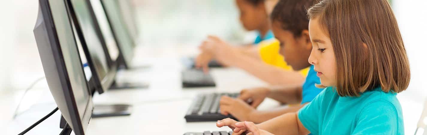 Niños con ordenadores y tecnología en las aulas