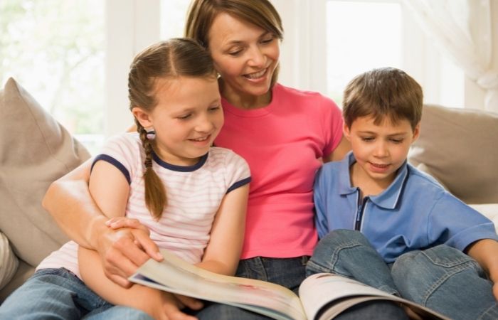 libros de sexualidad: madre leyendo con su hija e hijo