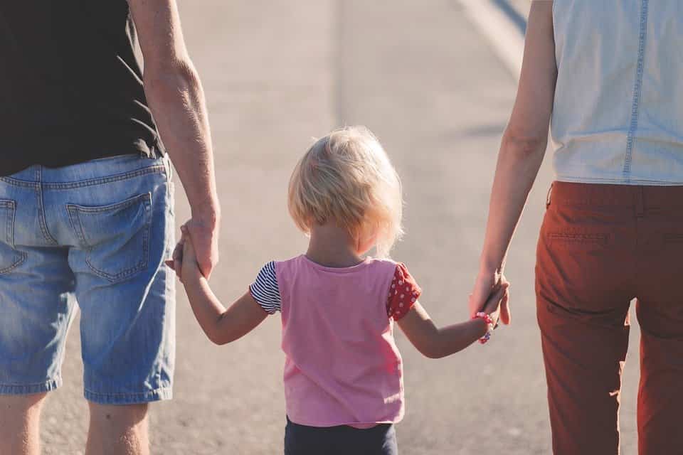 Padres paseando de la mano con su hija