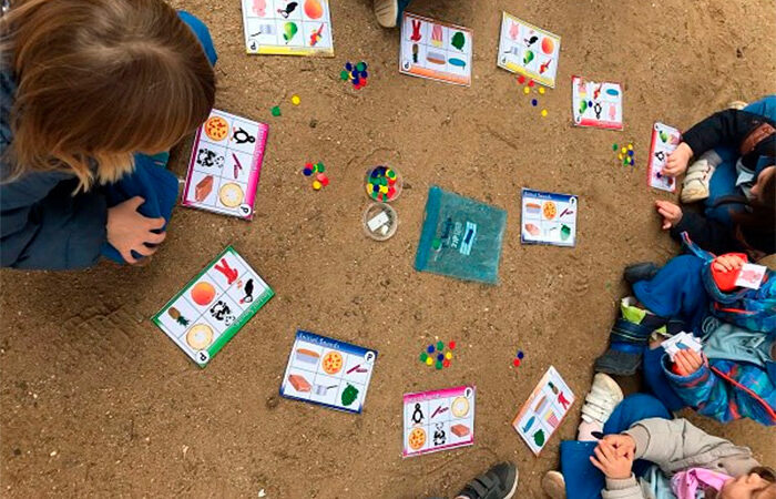 aprendizaje al aire libre Niños jugando con cartulinas, fichas y otros elementos