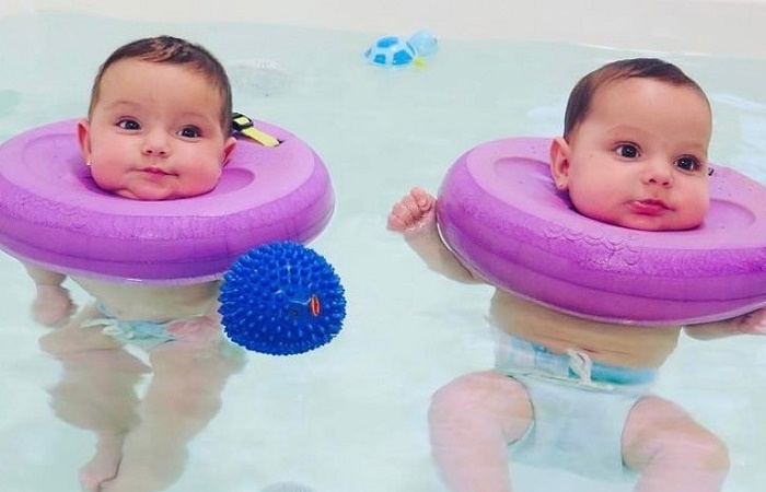 Bebés con flotador en la bañera de un spa. Hidroterapia para bebés
