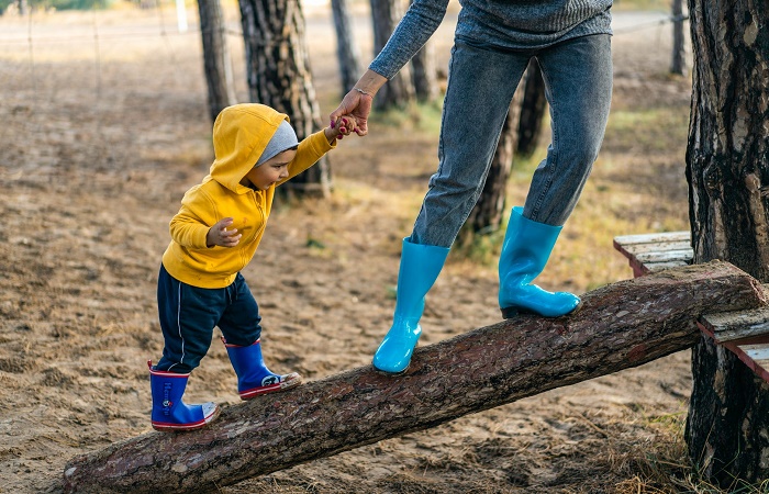 Niño con su madre en un parque, con botas de agua Jugar con barro 