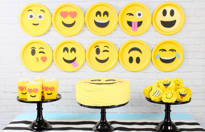 Platos y dulces decorados con emoticonos para hacer una fiesta