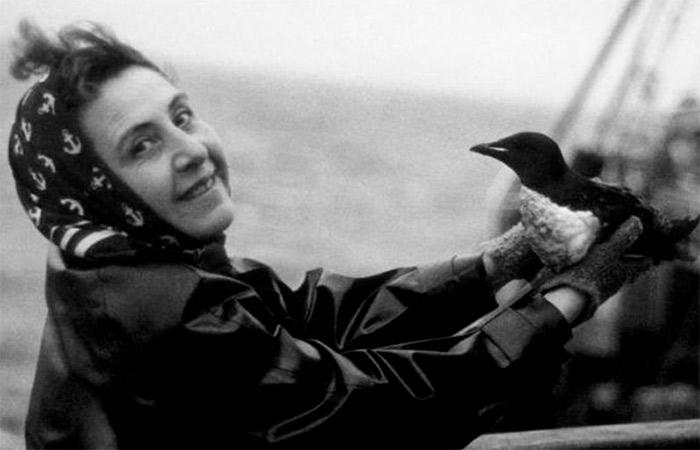 Anita Conti, en un barco y sujetando un ave