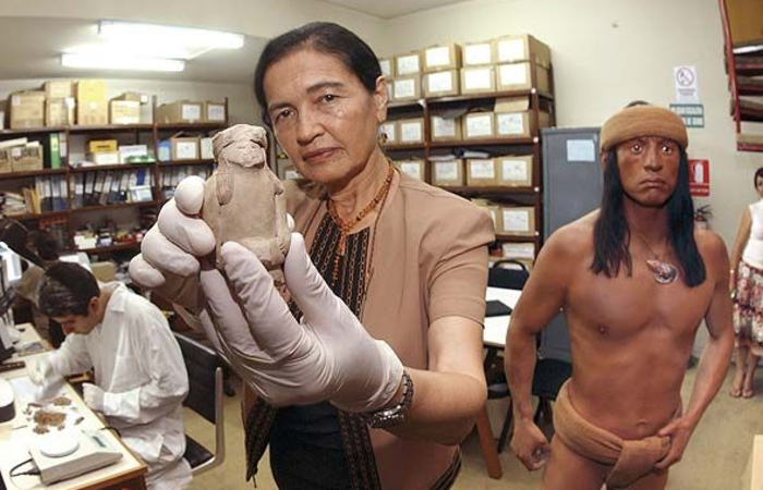 Ruth Shady  muestra una pieza de un pequeño busto indígena