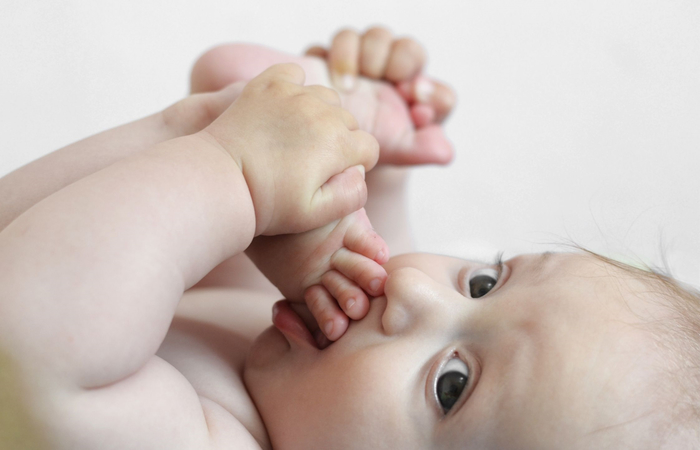 bebé chupándose los dedos del pie