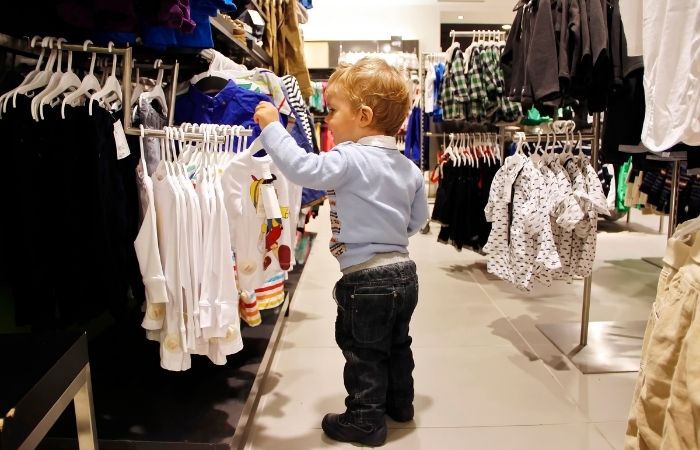 niño elige su propia ropa en tienda