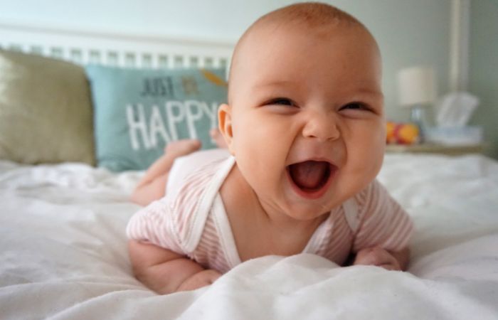 la viva imagen de un bebé feliz riéndose
