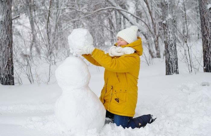 adolescente haciendo un muñeco de nieve