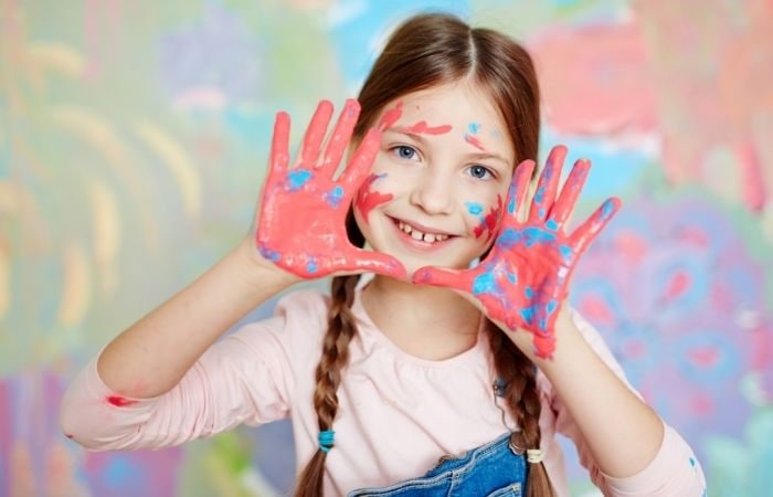 Creatividad jóvenes: niña con pintura en las manos