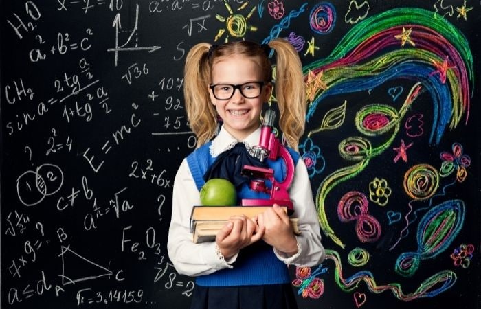 Creatividad : niña ante pizarra con operaciones matemáticas a un lado y dibujos de colores al otro
