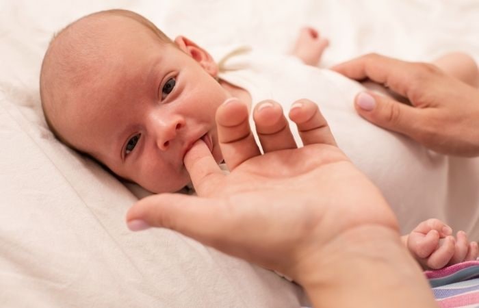 Los bebés nacen con reflejos: recién nacido succionando un dedo materno