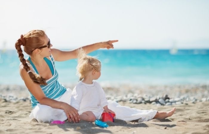 Da ejemplo al señalar, como esta madre señalando en la playa